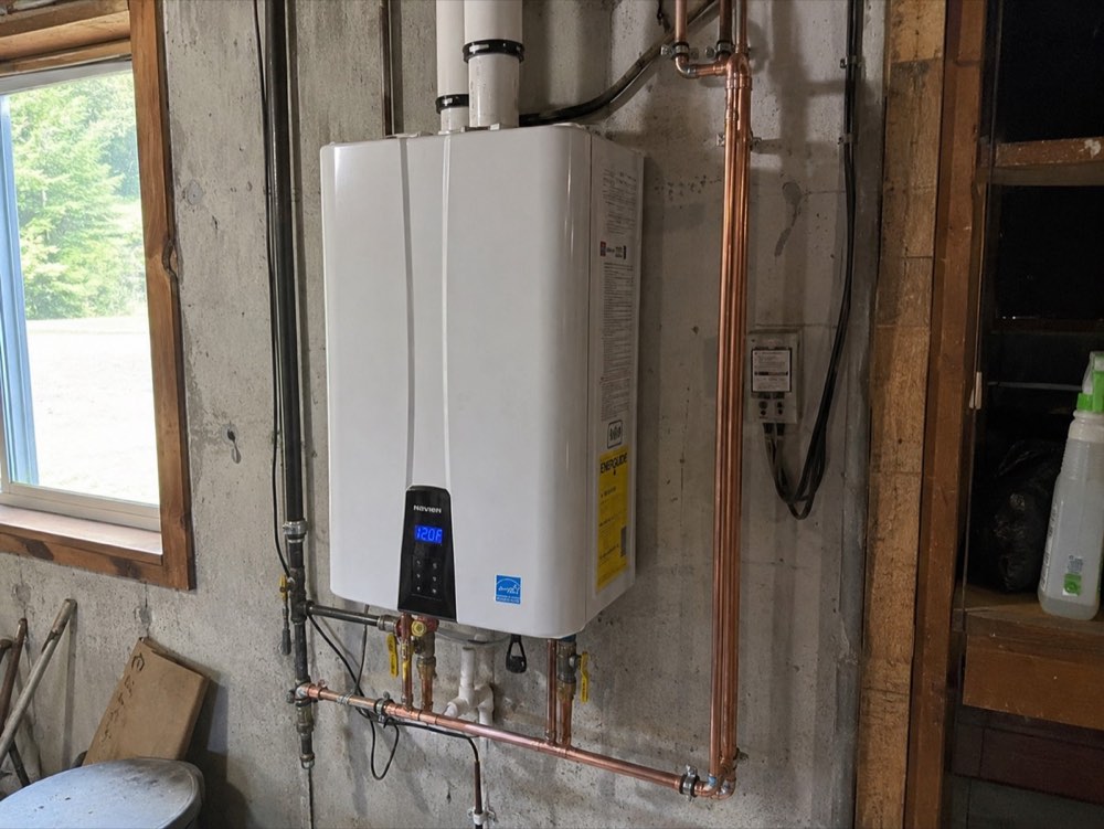 Tankless water heater installed on a basement wall with new copper lines